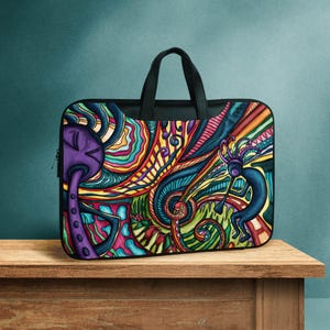 May include: A rectangular laptop bag featuring a vibrant, multi-colored abstract design with swirling patterns, a purple mushroom-like figure on the left, and a blue flute-playing figure on the right, all set against a black fabric frame.