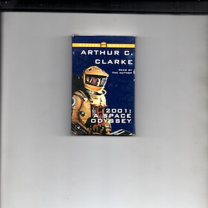 May include: A blue and yellow cassette tape case with the title "2001: A Space Odyssey" by Arthur C. Clarke, read by the author.