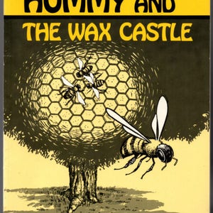 May include: A yellow book cover with the title "Hummy and the Wax Castle" in black text. The cover features a cartoon illustration of a beehive with bees flying around it.