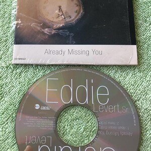 May include: A CD single by Gerald & Eddie Levert titled "Already Missing You". The cover art features a close-up of a vintage pocket watch with a white face and black hands.