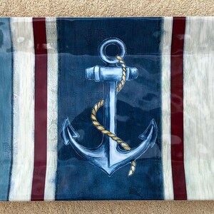 May include: Rectangular serving tray with a nautical theme. The tray features a blue anchor with a rope, set against a background of blue, white, and burgundy vertical stripes. The tray is approximately 18 inches long.