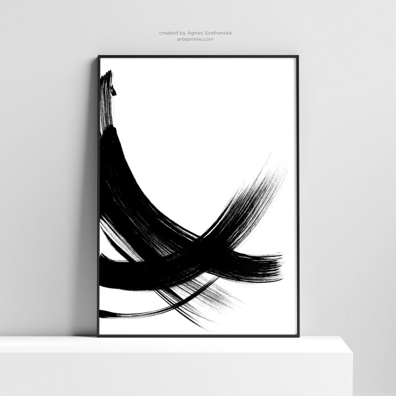 Black and white abstract art print with bold brushstrokes in a minimalist style. The print features a series of overlapping lines and curves, creating a dynamic and energetic composition.
Over the print, there is a text: "created by Agnes Szafranska - arteprinte.com".