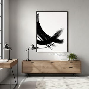 Modern minimalist black and white abstract art print with expressive bold brush strokes hanging in a Scandi-industrial home office above a wooden sideboard.
Below the artwork, there is a text: "created by Agnes Szafranska - arteprinte.com".