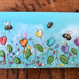 rainbow encaustic bee painting with garden of rainbow flowers, beeswax painting by canadian artist Brenda walker from Calgary Alberta canada