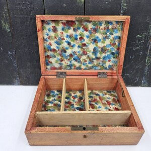 May include: Open wooden jewelry box with a floral patterned interior. The box is rectangular with three compartments and a lift-out tray. The interior fabric features a colorful pattern of red, blue, and green spots.