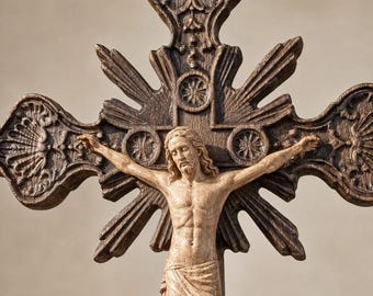 May include: A dark brown wooden crucifix featuring a detailed, light-toned figure of Jesus Christ centered on the cross. The cross has ornate, carved ends with shell-like patterns and radiating sunburst rays extending from the central intersection.