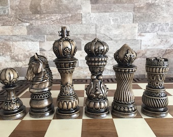 May include: Six ornate chess pieces in a variety of styles, including a king, queen, knight, bishop, and rook. The pieces are made of dark brown wood and have intricate carvings. They are arranged on a chessboard.