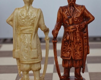 May include: Two chess pieces, a light beige and a brown figure, stand on a checkered board. The beige figure is a man in a long coat, holding a sword. The brown figure is a man in a detailed coat, also holding a sword. The pieces are part of a chess set.