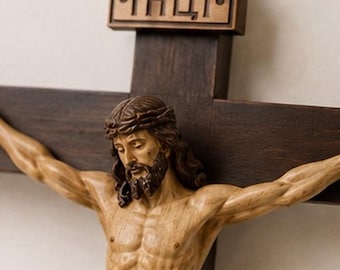 May include: A dark brown wooden crucifix featuring a carved figure of Jesus with a crown of thorns. Above the figure, a rectangular wooden plaque is attached to the cross, displaying the Cyrillic letters "ІНЦІ" in a raised, carved relief style.