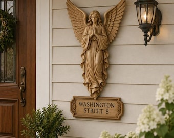 May include: A tan-colored wall-mounted angel sculpture with large, detailed wings and hands pressed together in prayer. Below the angel is a rectangular plaque with the text WASHINGTON STREET 8 in dark, embossed lettering on a tan background.