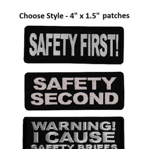 May include: Three black iron-on patches with white text. The first patch reads "SAFETY FIRST!" The second patch reads "SAFETY SECOND". The third patch reads "WARNING! I CAUSE SAFETY BRIEFS".