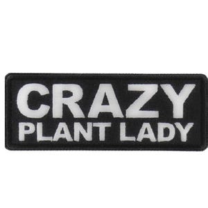 May include: Black rectangular patch with the words "CRAZY PLANT LADY" in bold white letters. The patch is a simple, rectangular shape, and the text is centered.