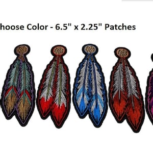 May include: Six embroidered iron-on patches featuring a pair of feathers with a beaded top. The patches are 6.5 inches by 2.25 inches and come in a variety of colors including red, blue, purple, orange, and green.