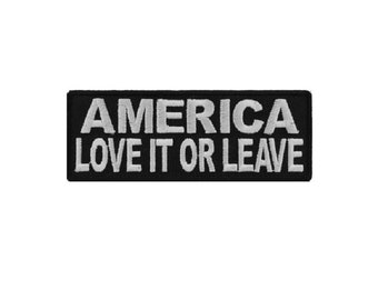 May include: Black and white embroidered patch with the text "America Love It Or Leave"