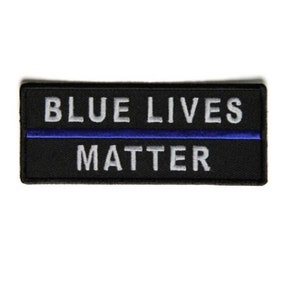 May include: Black embroidered patch with a thin blue line and the text "BLUE LIVES MATTER" in white.