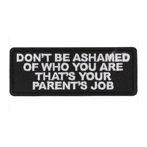 May include: A rectangular black patch with white embroidered text that reads: "DON'T BE ASHAMED OF WHO YOU ARE THAT'S YOUR PARENT'S JOB."