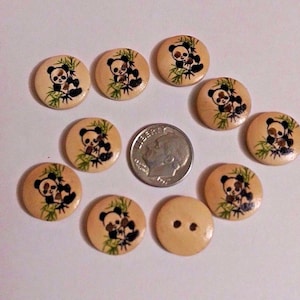 May include: A set of ten wooden buttons with a panda bear design. The buttons are beige with brown panda bears and green leaves. One button is plain beige with two holes.