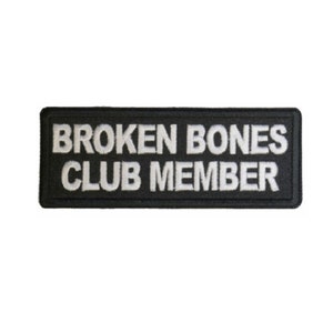 May include: Black embroidered patch with white text that reads "BROKEN BONES CLUB MEMBER".