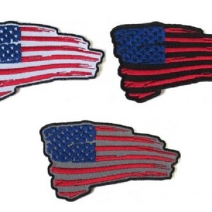 May include: Three embroidered patches featuring the American flag in different color variations. The first patch is red, white, and blue. The second patch is black, red, and blue. The third patch is gray, red, and blue.