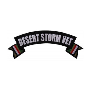 May include: Black and white embroidered patch with the text "Desert Storm Vet" on a curved banner with green, white, and red stripes on the ends.