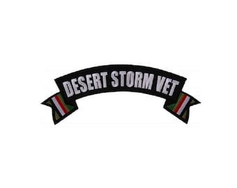 May include: Black and white embroidered patch with the text "Desert Storm Vet" on a curved banner with green, white, and red stripes on the ends.