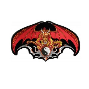 May include: Red and gold dragon with black wings holding a yin yang symbol. The dragon is sitting on a black and silver tribal design.