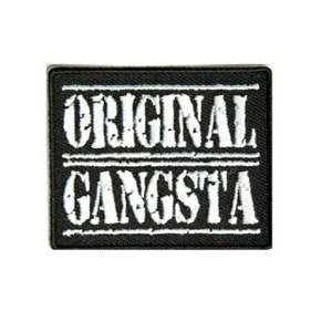 May include: Black and white embroidered patch with the text "ORIGINAL GANGSTA" in a distressed font.