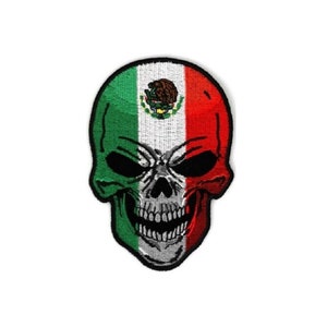 May include: A black and white skull with the Mexican flag colors of green, white, and red. The skull has a menacing expression with black eyes and a wide open mouth.
