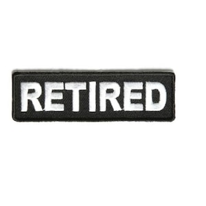May include: Black embroidered patch with white text that reads "RETIRED".