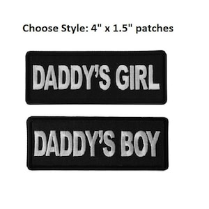 May include: Two black iron-on patches with white embroidery. The top patch reads "Daddy's Girl" and the bottom patch reads "Daddy's Boy".