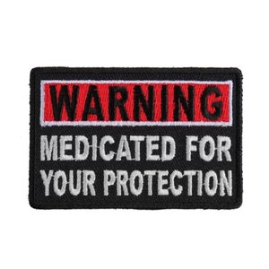 May include: Black embroidered patch with white text that reads "WARNING MEDICATED FOR YOUR PROTECTION" and a red rectangle with black text that reads "WARNING".