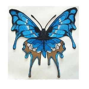 May include: A blue and brown embroidered butterfly with dripping edges. The butterfly is a popular motif for crafts and home decor.