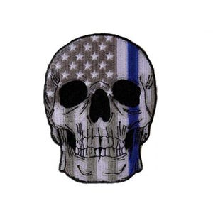 May include: An embroidered patch featuring a white skull with a thin blue line superimposed over an American flag design.