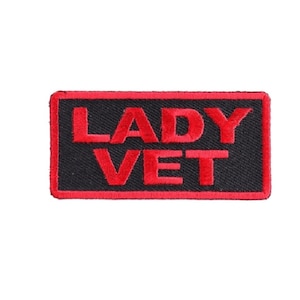 May include: Red embroidered patch with black background and the text "LADY VET" in red.