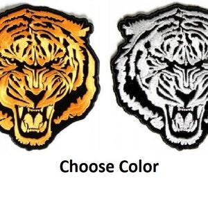 May include: Two embroidered iron-on patches of a tiger's face. The tiger has a black outline and a white background. One patch is gold and the other is white. Choose Color.