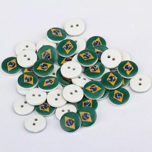 May include: A pile of round, wooden buttons with a green, yellow, and blue design. The buttons have two holes each.