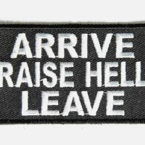 May include: Black rectangular patch with white embroidered text that reads "ARRIVE RAISE HELL LEAVE". The patch has a black border and is likely made of fabric. The text is in a bold, sans-serif font.