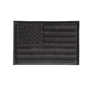 May include: Black embroidered American flag patch. The flag is made of a black fabric with white stitching.