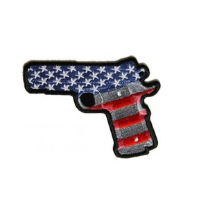 May include: An embroidered patch shaped like a handgun with the American flag design. The stars are white, the stripes are red and white, and the outline is black.