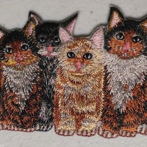 May include: Three embroidered cat patches, one orange and white tabby, one black and white calico, and one brown and white calico. The patches are all about 2 inches tall and 2 inches wide.