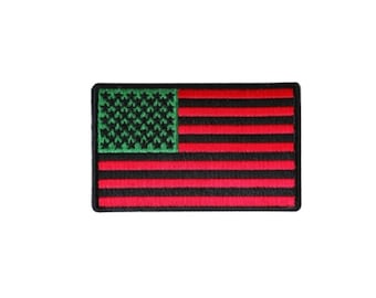 May include: A red, black, and green embroidered American flag patch. The stars are green and the stripes are red and black.
