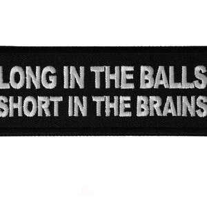 May include: Black embroidered patch with white text that reads "Long in the Balls Short in the Brains".