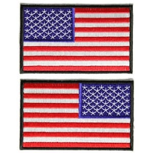 May include: Two embroidered American flag patches. Each patch is rectangular with a black border and features a red, white, and blue American flag design.