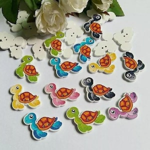 May include: Assortment of colorful wooden turtle buttons with painted details. The buttons are various sizes and feature different colors and patterns.