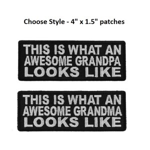 May include: Two black iron-on patches with white text. The top patch reads "This is what an awesome grandpa looks like". The bottom patch reads "This is what an awesome grandma looks like".