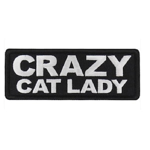 May include: Black and white embroidered patch with the text "Crazy Cat Lady" in white lettering.