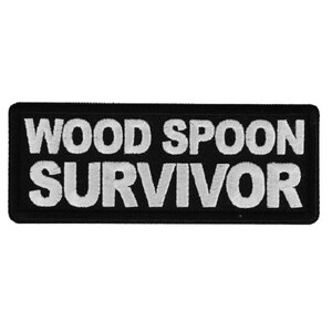 May include: Black embroidered patch with white text that reads "WOOD SPOON SURVIVOR".