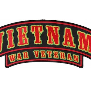 May include: A black embroidered patch with red and yellow lettering that reads "VIETNAM WAR VETERAN". The patch has a green outline.
