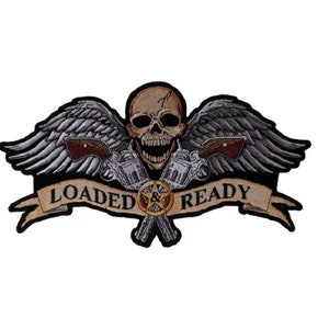 May include: A black and white embroidered patch with a skull with wings and two pistols crossed behind it. The skull is grinning and has a star in its mouth. A banner below the skull reads "LOADED & READY".