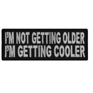 May include: Black embroidered patch with white text that reads "I'm not getting older I'm getting cooler".